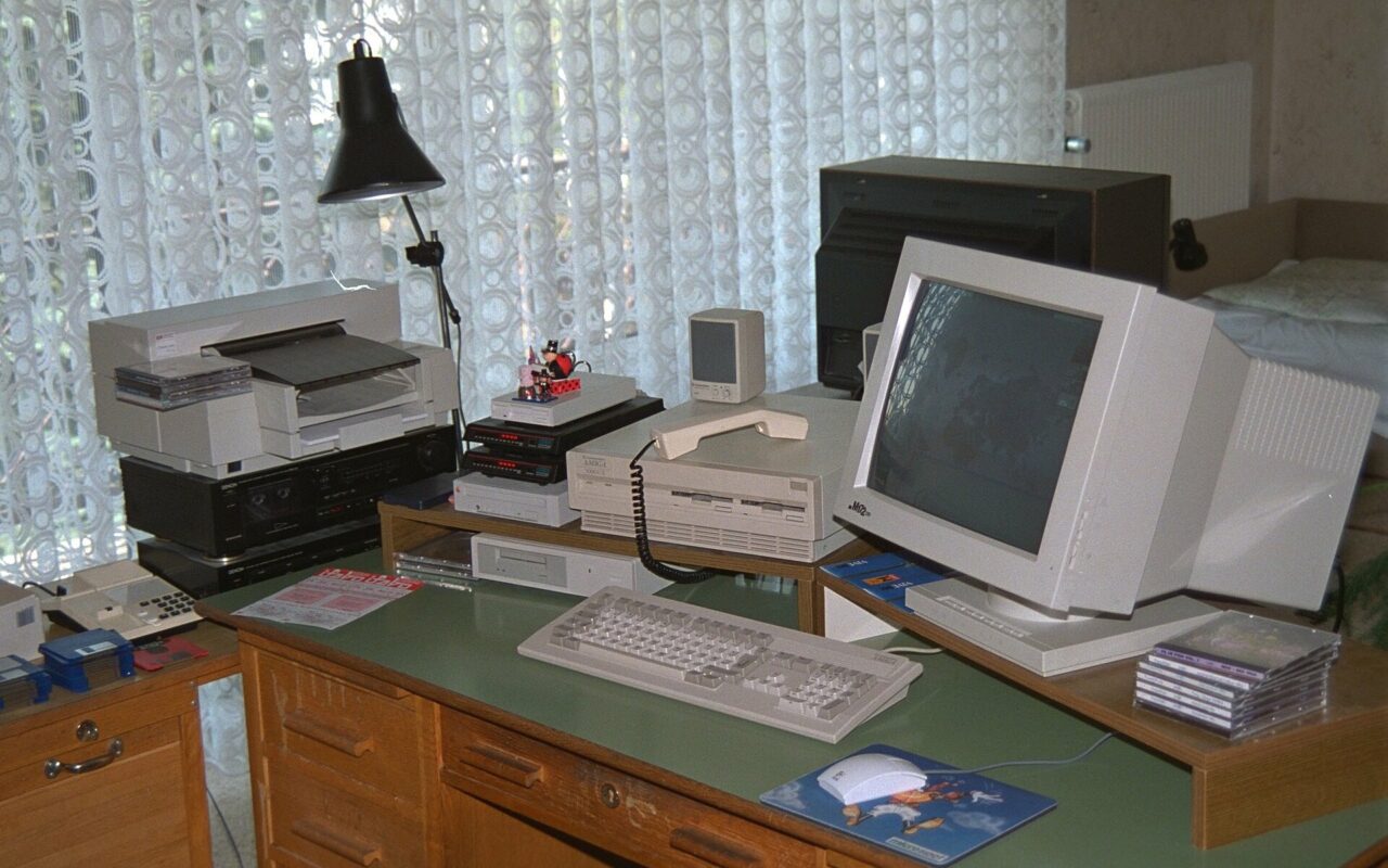 Un Amiga 3000UX sur un bureau, avec son moniteur, son clavier et une imprimante, dans une installation des années 1990