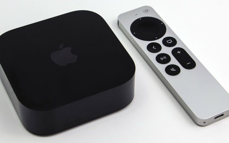 Un boitier Apple TV 4K noir pose a cote de la telecommande Siri Remote argentee, sur fond blanc