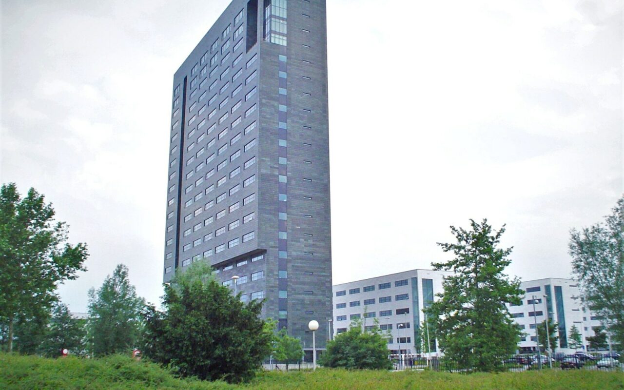 Tour du siège d'ASML à Veldhoven, aux Pays-Bas, entourée de bâtiments bas et d'arbres
