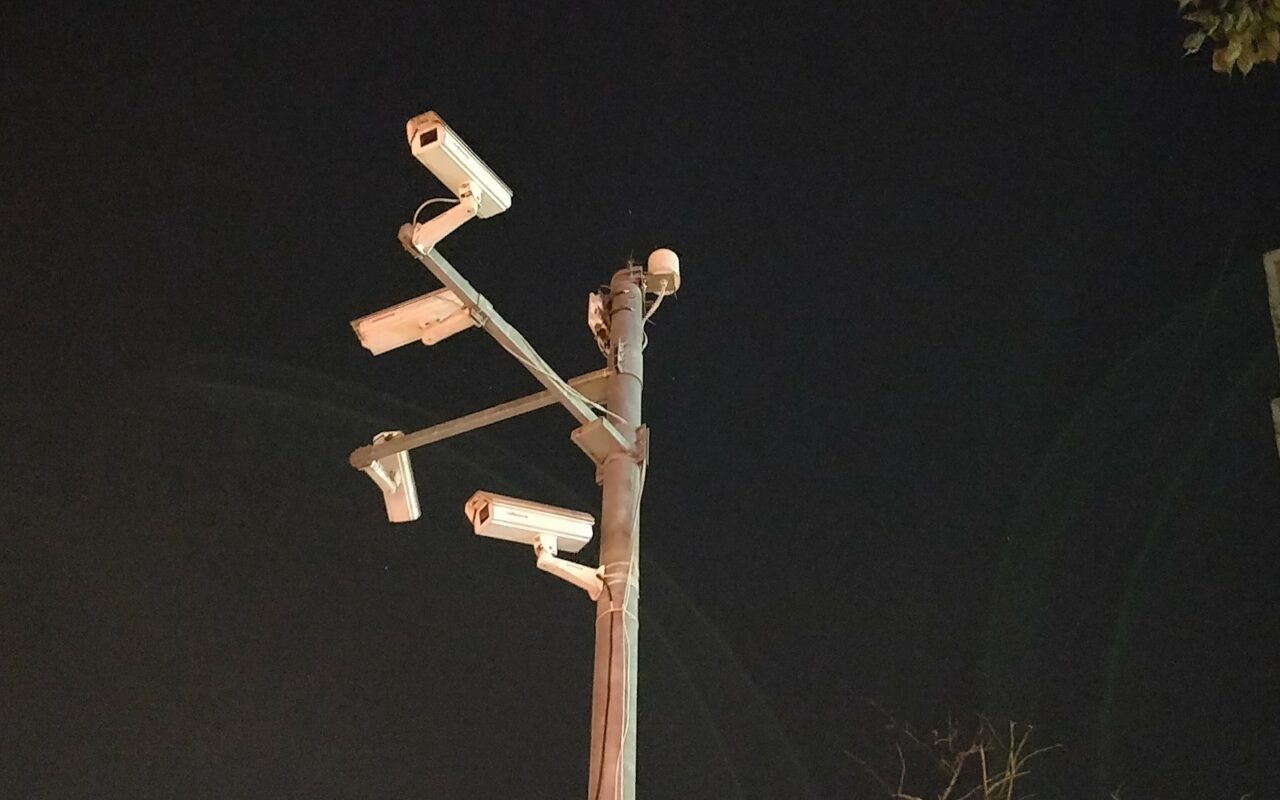 Plusieurs caméras de vidéosurveillance fixées sur un même mât, en ville.