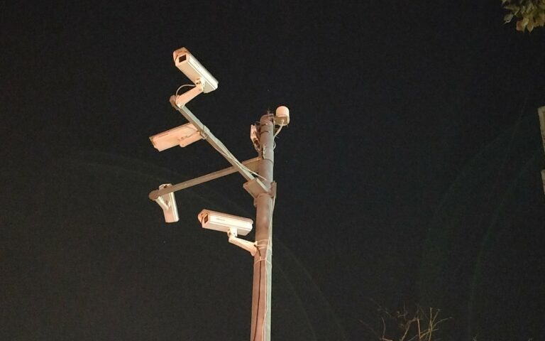 Plusieurs caméras de vidéosurveillance fixées sur un même mât, en ville.
