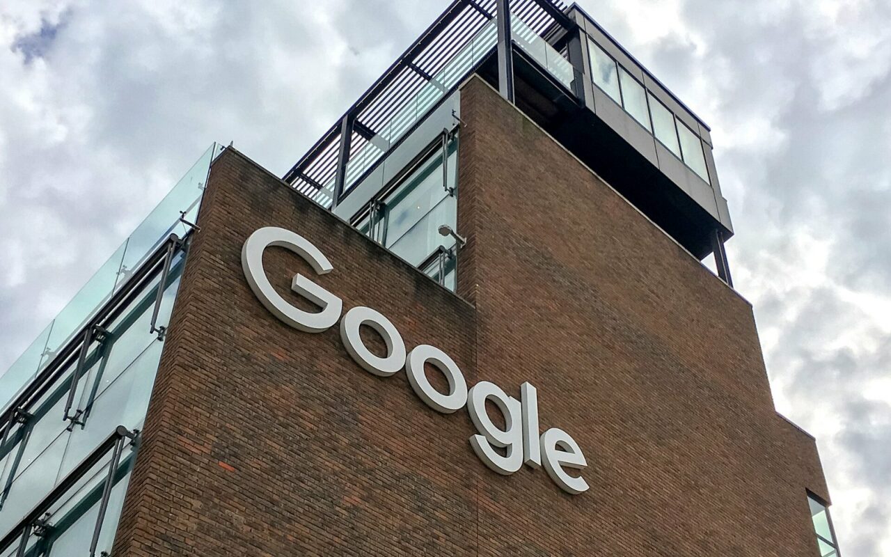 Façade en brique du siège irlandais de Google à Dublin, avec le logo Google en lettres blanches, sous un ciel nuageux