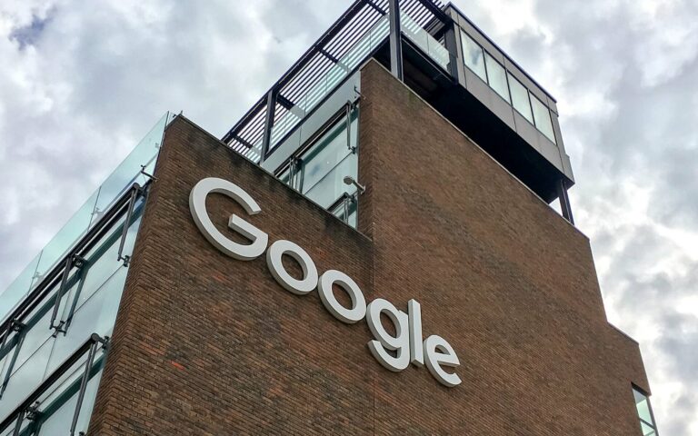 Façade en brique du siège irlandais de Google à Dublin, avec le logo Google en lettres blanches, sous un ciel nuageux