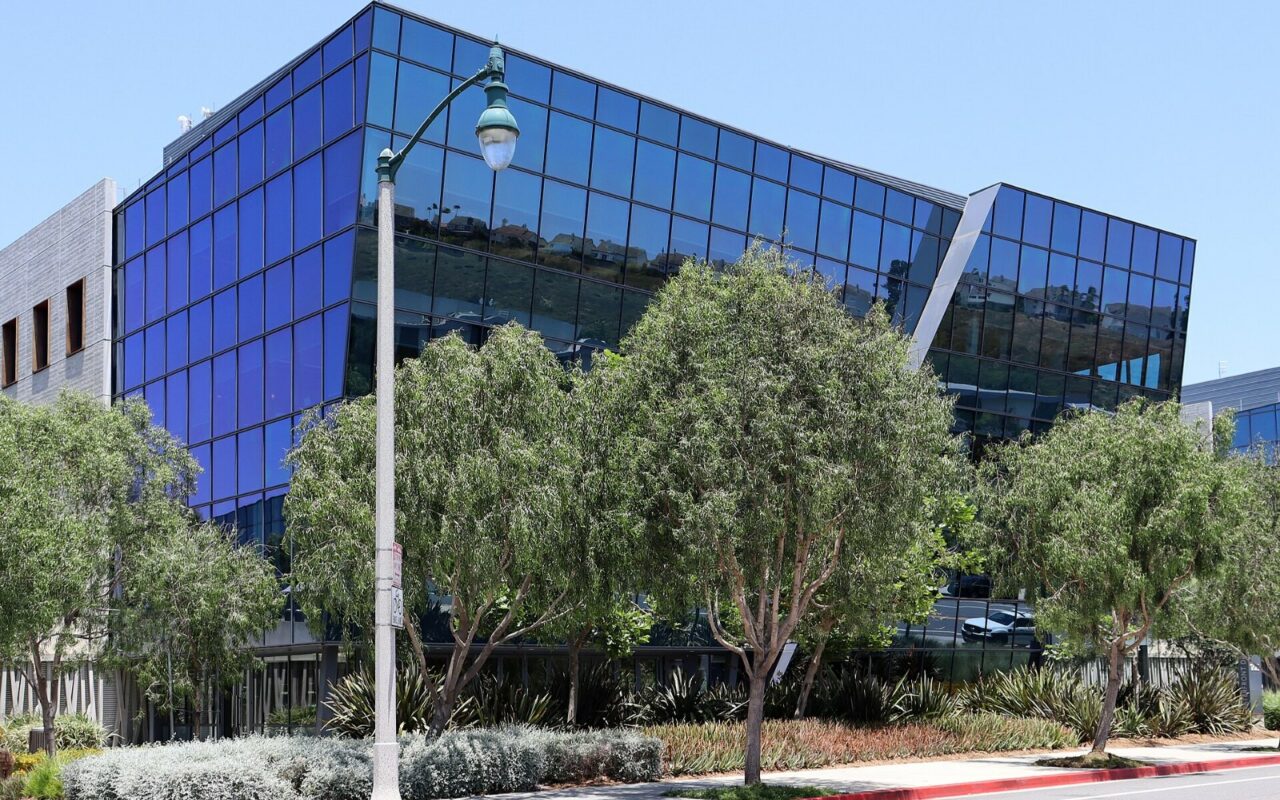 Façade vitrée du siège de l'ICANN à Los Angeles, avec des arbres au premier plan