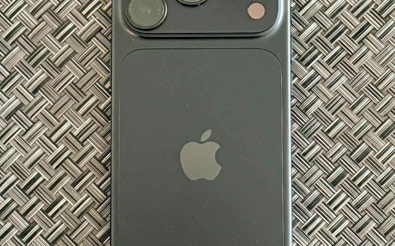 iPhone 18 Pro noir vu de dos, posé sur une surface tressée