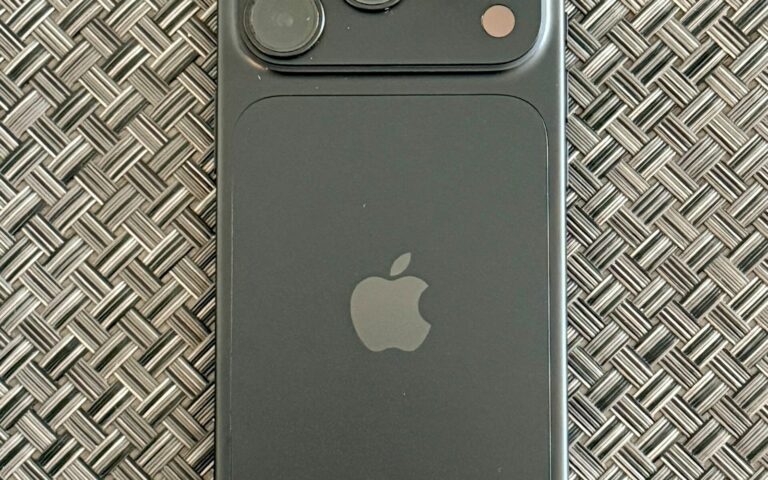 iPhone 18 Pro noir vu de dos, posé sur une surface tressée