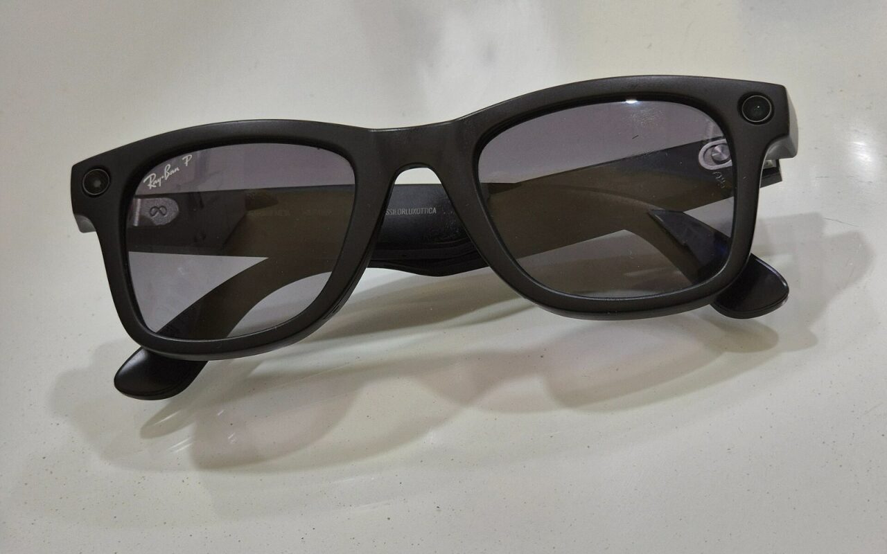 Paire de lunettes connectées à monture sombre, posée sur une surface claire