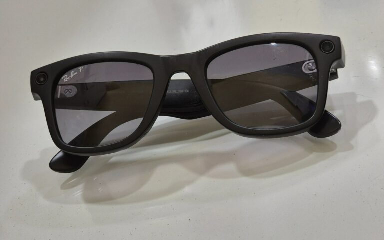 Paire de lunettes connectées à monture sombre, posée sur une surface claire