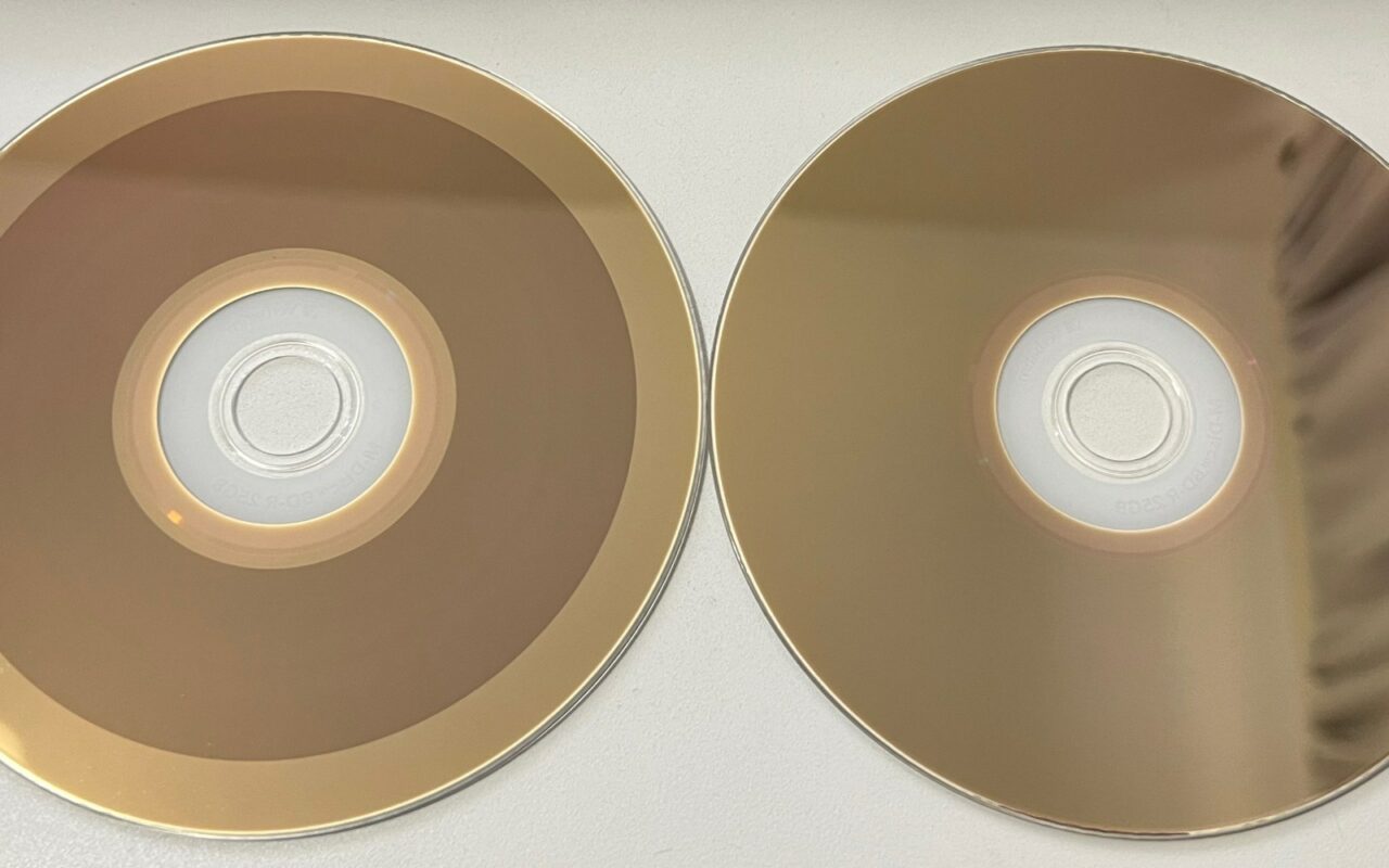 Deux disques M-DISC, l'un vierge et l'autre gravé, côte à côte