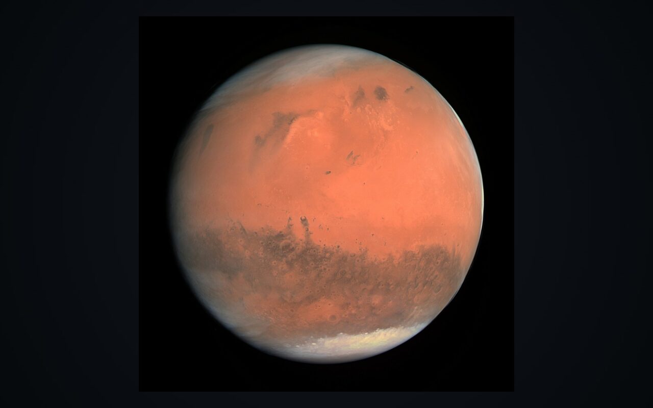 Le disque de la planète Mars en couleurs réelles sur fond noir, calottes et reliefs visibles