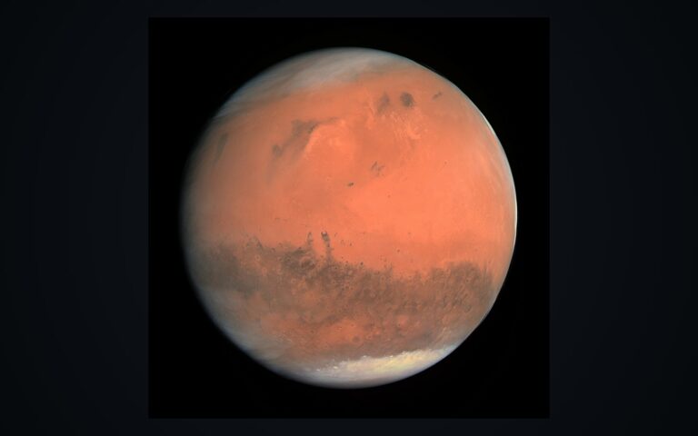 Le disque de la planète Mars en couleurs réelles sur fond noir, calottes et reliefs visibles