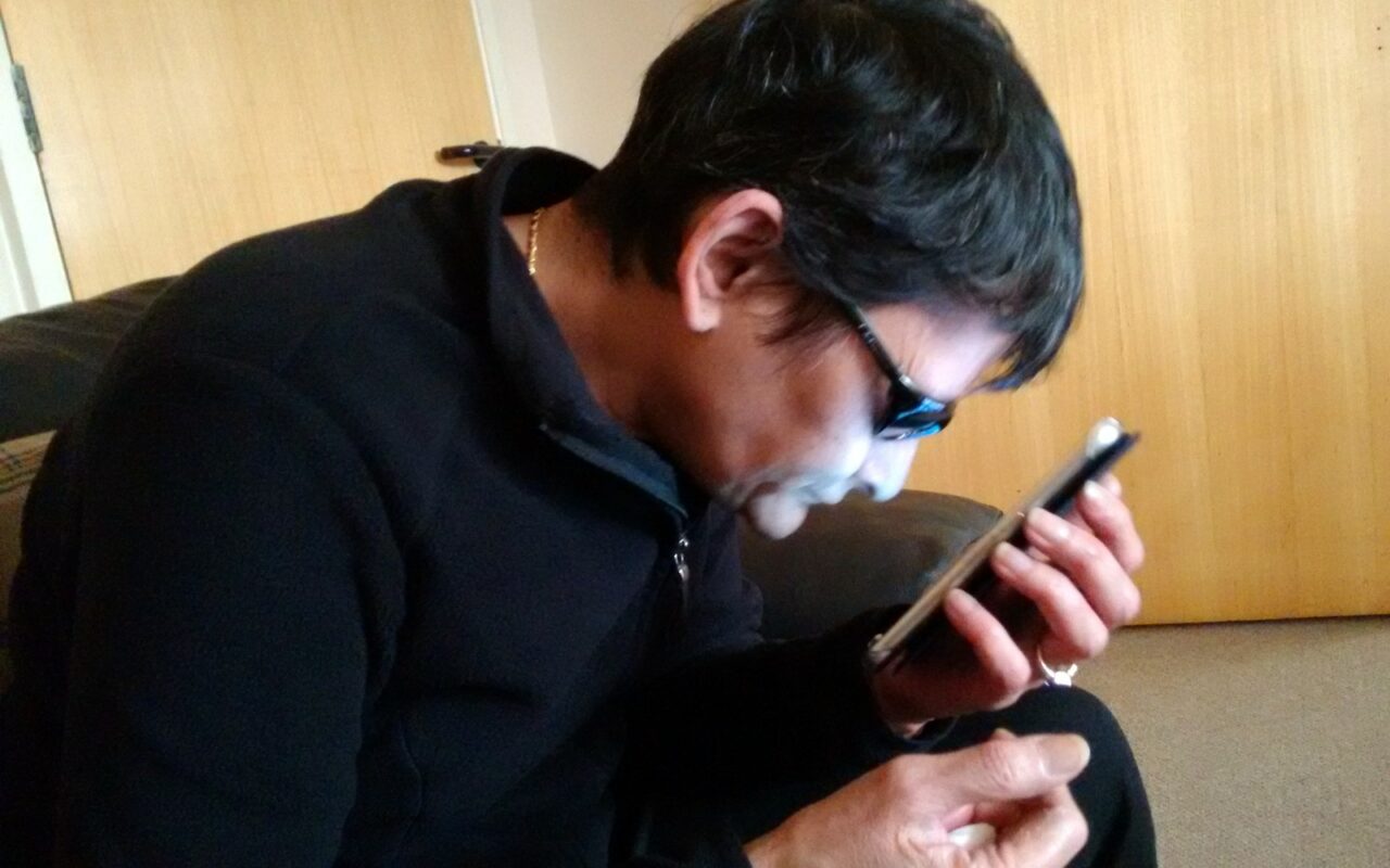 Une personne tient un téléphone Android et consulte son écran.
