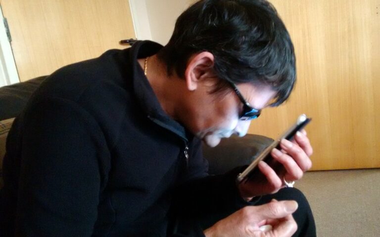 Une personne tient un téléphone Android et consulte son écran.
