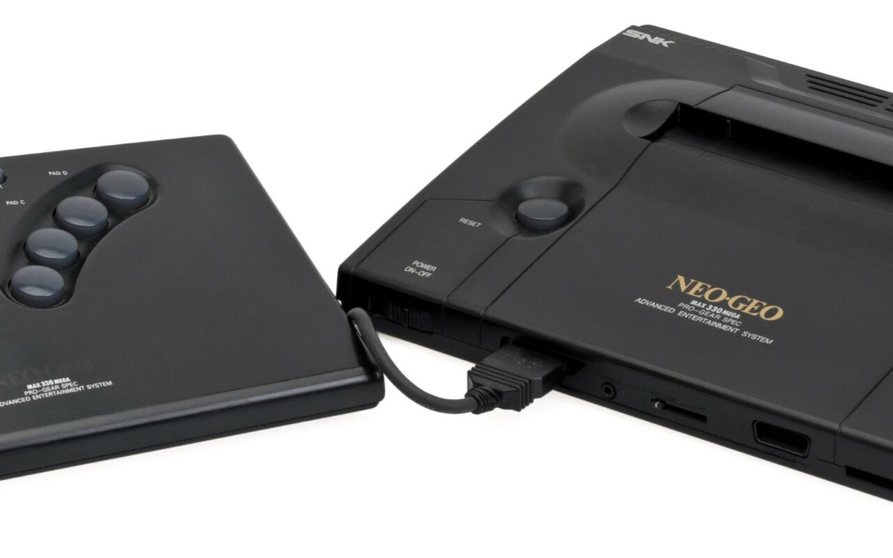 Une console de jeu Neo Geo AES accompagnée de sa manette à levier.