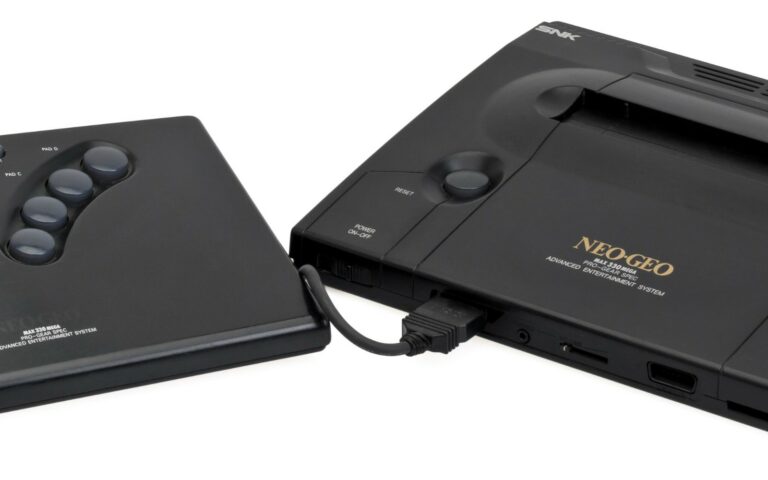 Une console de jeu Neo Geo AES accompagnée de sa manette à levier.