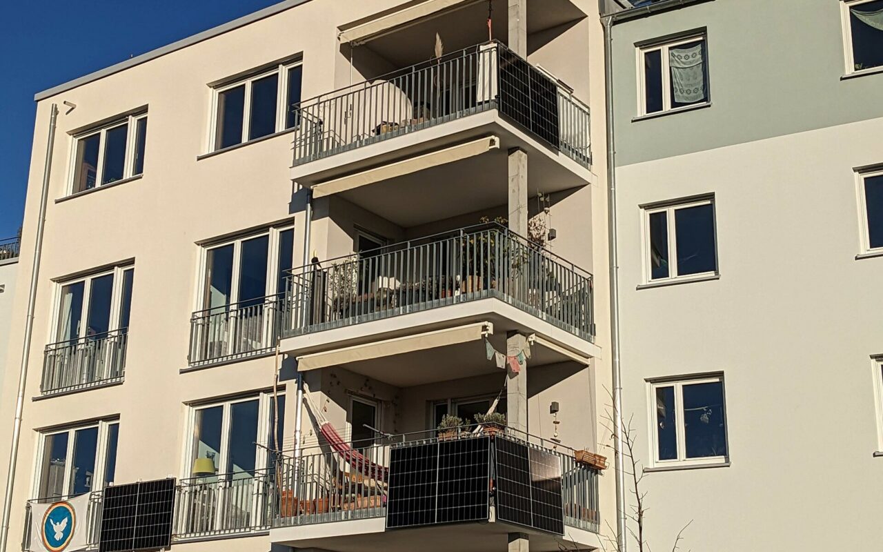 Panneaux solaires fixés à la rambarde d’un balcon d’immeuble