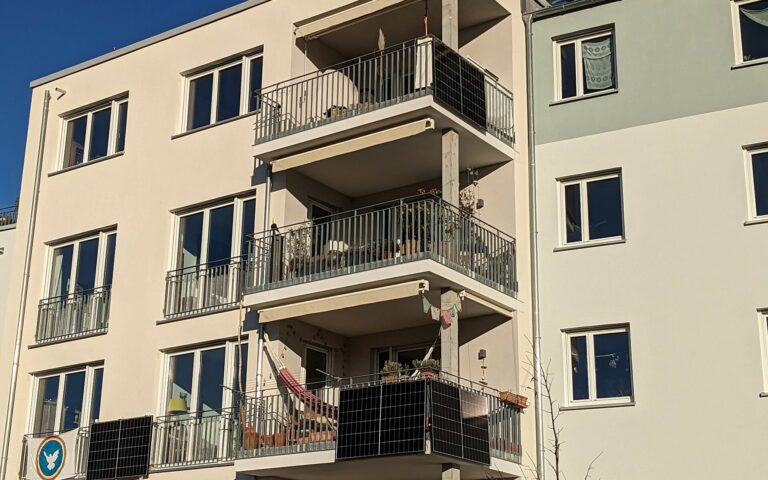 Panneaux solaires fixés à la rambarde d’un balcon d’immeuble