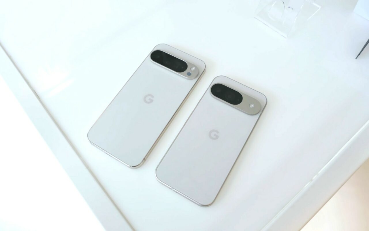 Deux smartphones Google Pixel 9 blancs posés côte à côte sur une table claire, dos vers le haut, barre photo et logo G visibles