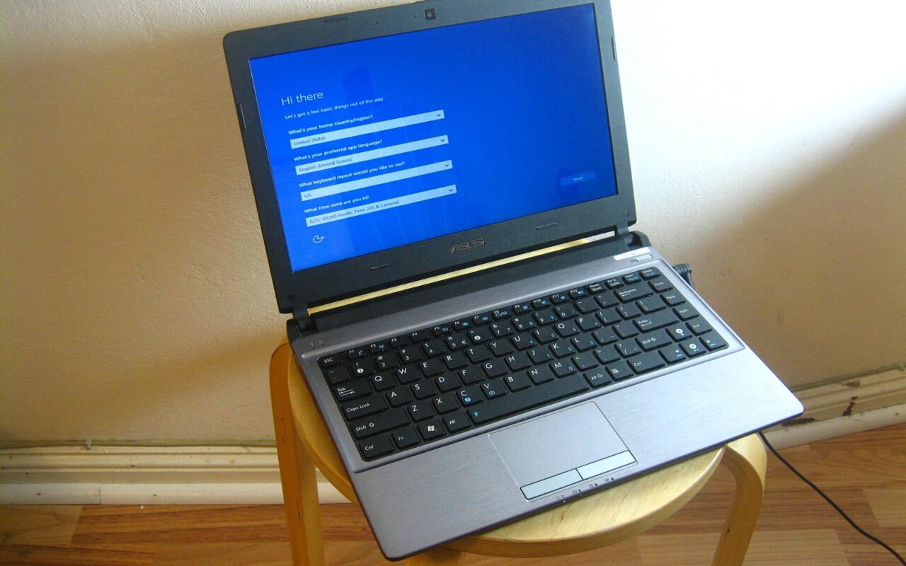 Un ordinateur portable posé sur un tabouret, l'écran bleu de configuration de Windows affiché