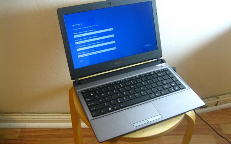 Un ordinateur portable posé sur un tabouret, l'écran bleu de configuration de Windows affiché