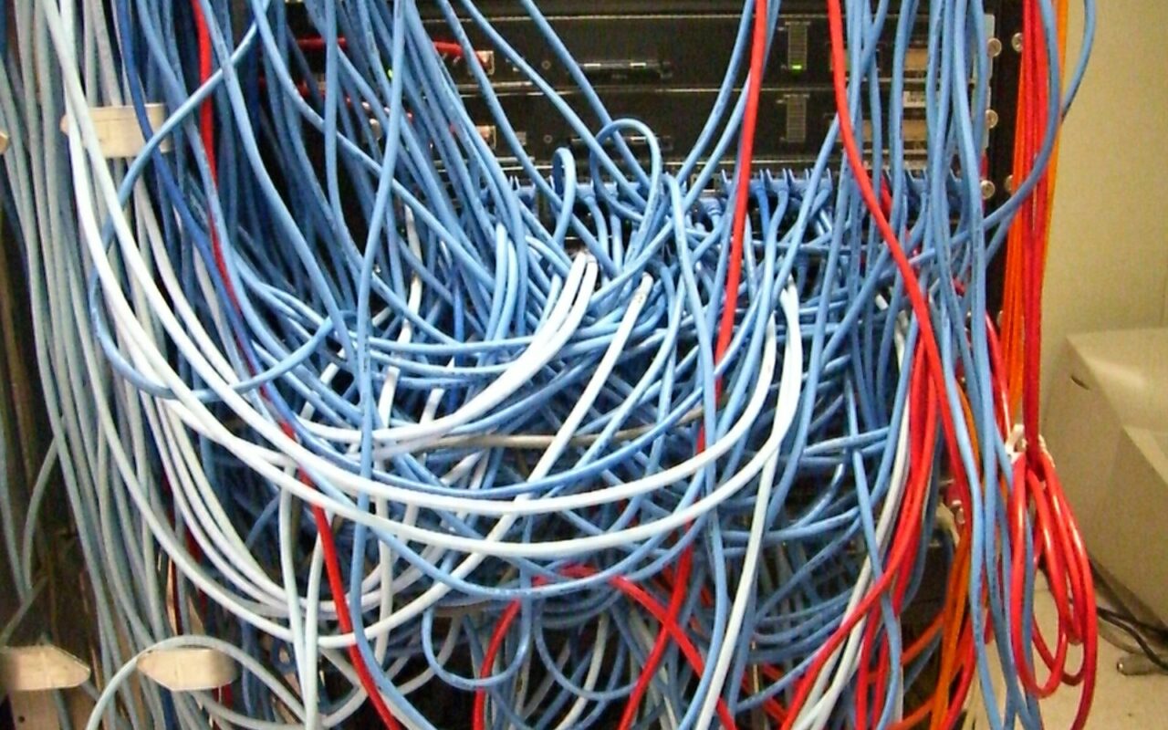 Baie informatique remplie dâun enchevĂȘtrement de cĂąbles rĂ©seau bleus et rouges