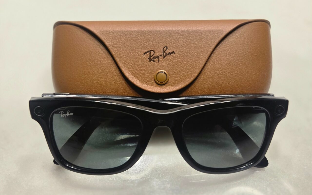 Une paire de lunettes connectées Ray-Ban Meta posée à côté de son étui de recharge