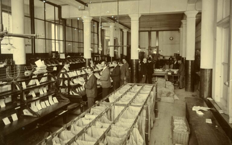 Employes des postes triant le courrier dans une vaste salle au debut du vingtieme siecle