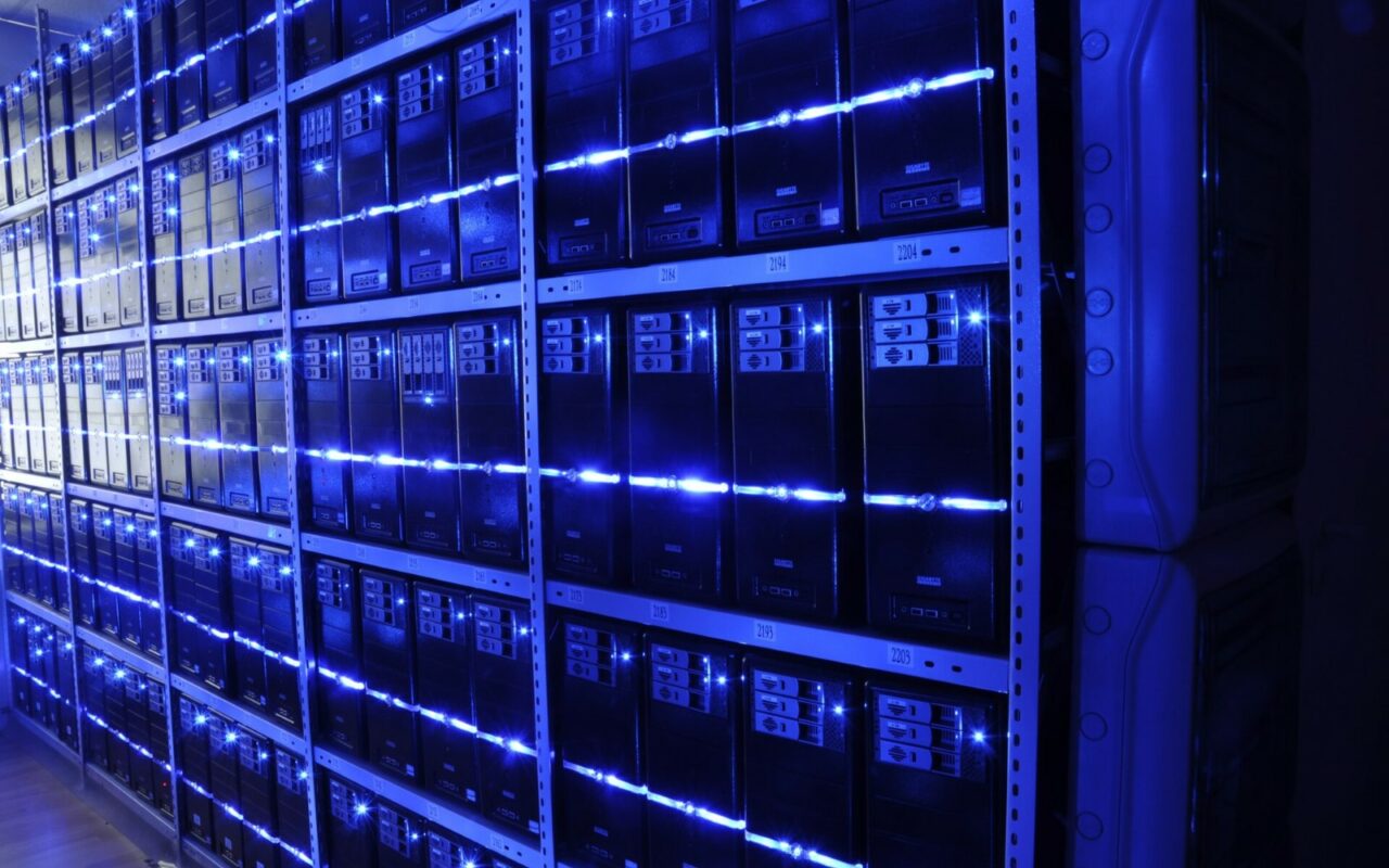 Allées de baies de serveurs éclairées en bleu dans une salle informatique