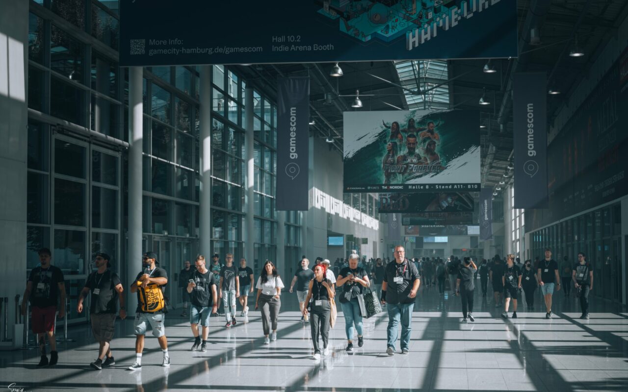 Foule de visiteurs circulant dans les allees d un grand salon consacre au jeu video