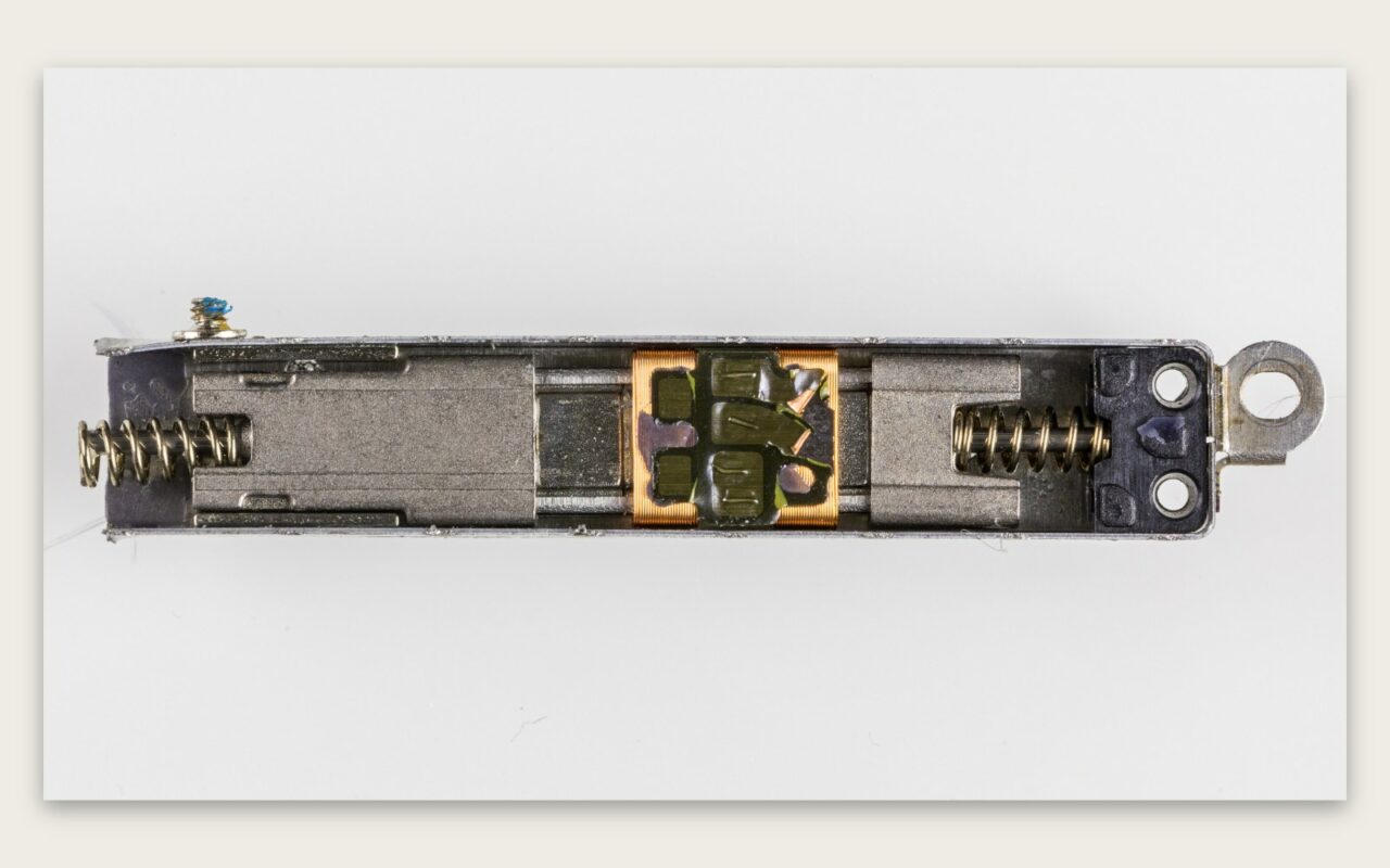 Taptic Engine d'iPhone ouvert, montrant l'aimant, les ressorts et la masse mobile du vibreur