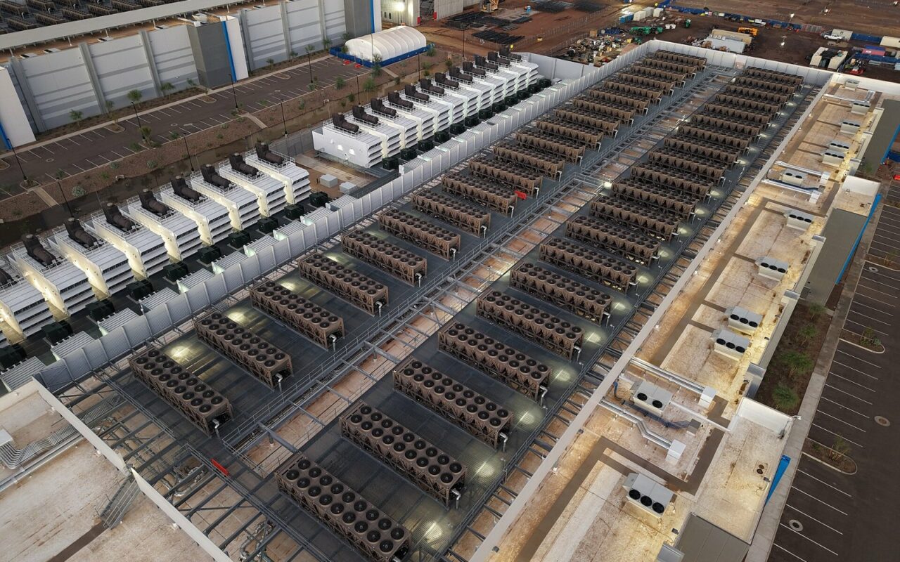 Toit d’un centre de données couvert de rangées de tours de refroidissement et de groupes électrogènes