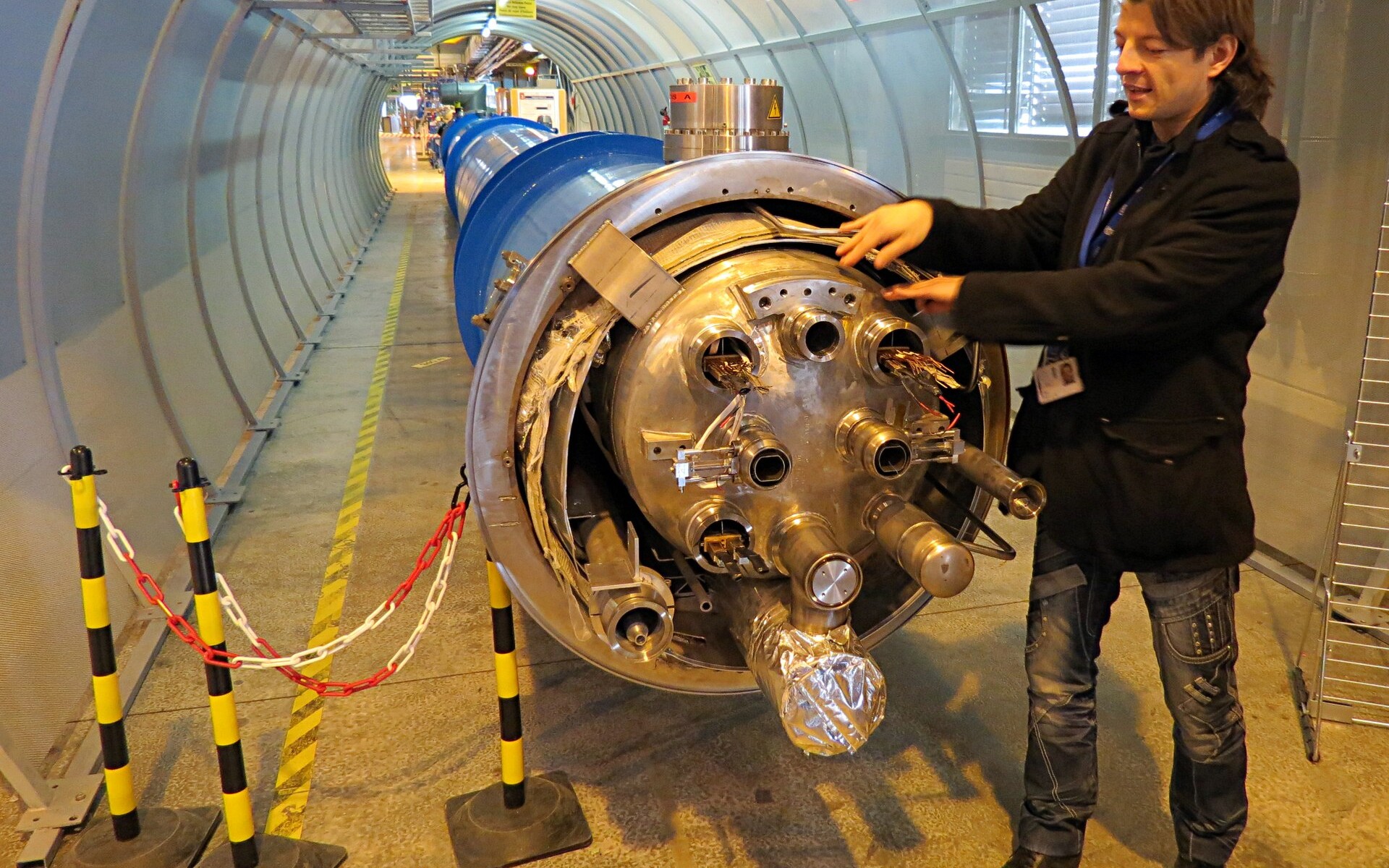 Tunnel de l’accélérateur du CERN, avec la ligne d’aimants bleus qui s’enfonce dans la courbe