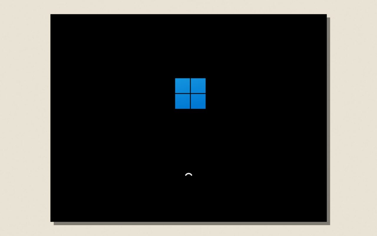 Ecran de demarrage de Windows 11 pendant une mise a jour, pose sur un fond papier
