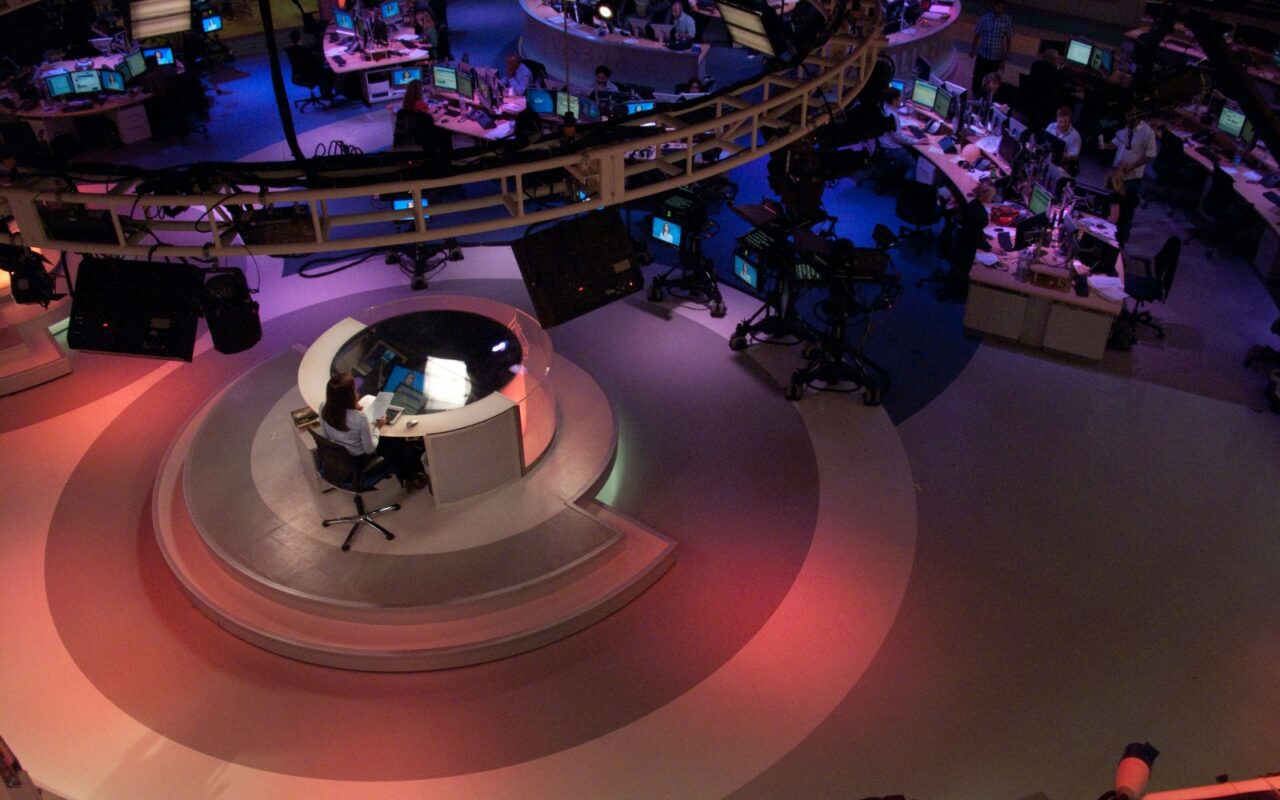 Salle de rédaction d'Al Jazeera English, avec des journalistes à leurs postes devant des écrans