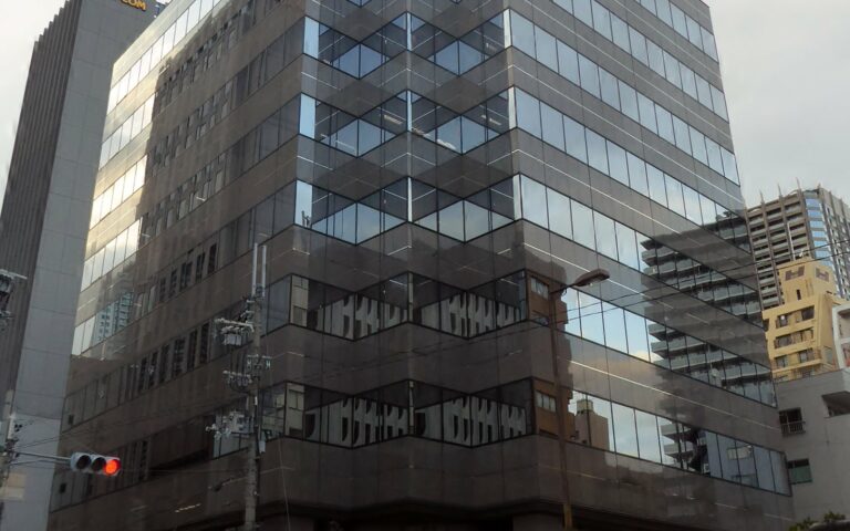 Immeuble de bureaux vitré du siège de Capcom à Osaka, vu depuis la rue