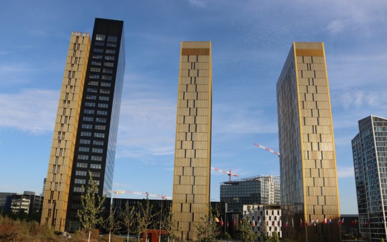 Deux tours dorées et une tour sombre de la Cour de justice de l'Union européenne sous un ciel bleu, à Luxembourg