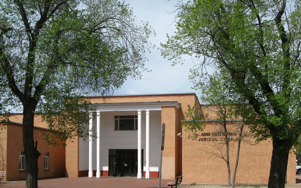 Façade en briques à colonnes blanches du complexe judiciaire de Santa Fe, entre deux arbres
