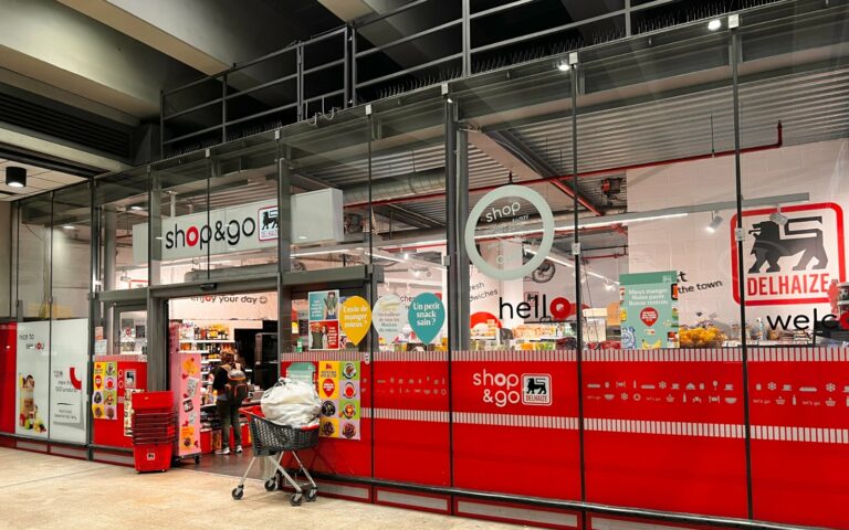 Façade rouge du magasin Delhaize Shop & Go dans la gare de Schuman, à Bruxelles.