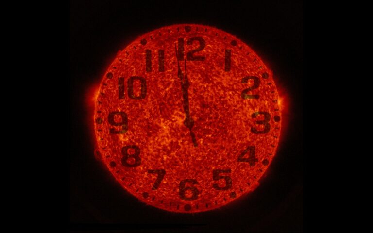 Image de la NASA : le disque orange du Soleil sert de cadran d'horloge, aiguilles juste avant midi, sur fond noir