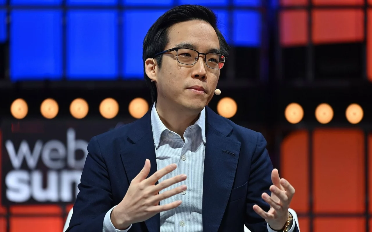 Andy Yen, fondateur de Proton, lunettes et veste bleu marine, parle en faisant des gestes des mains sur la scène du Web Summit