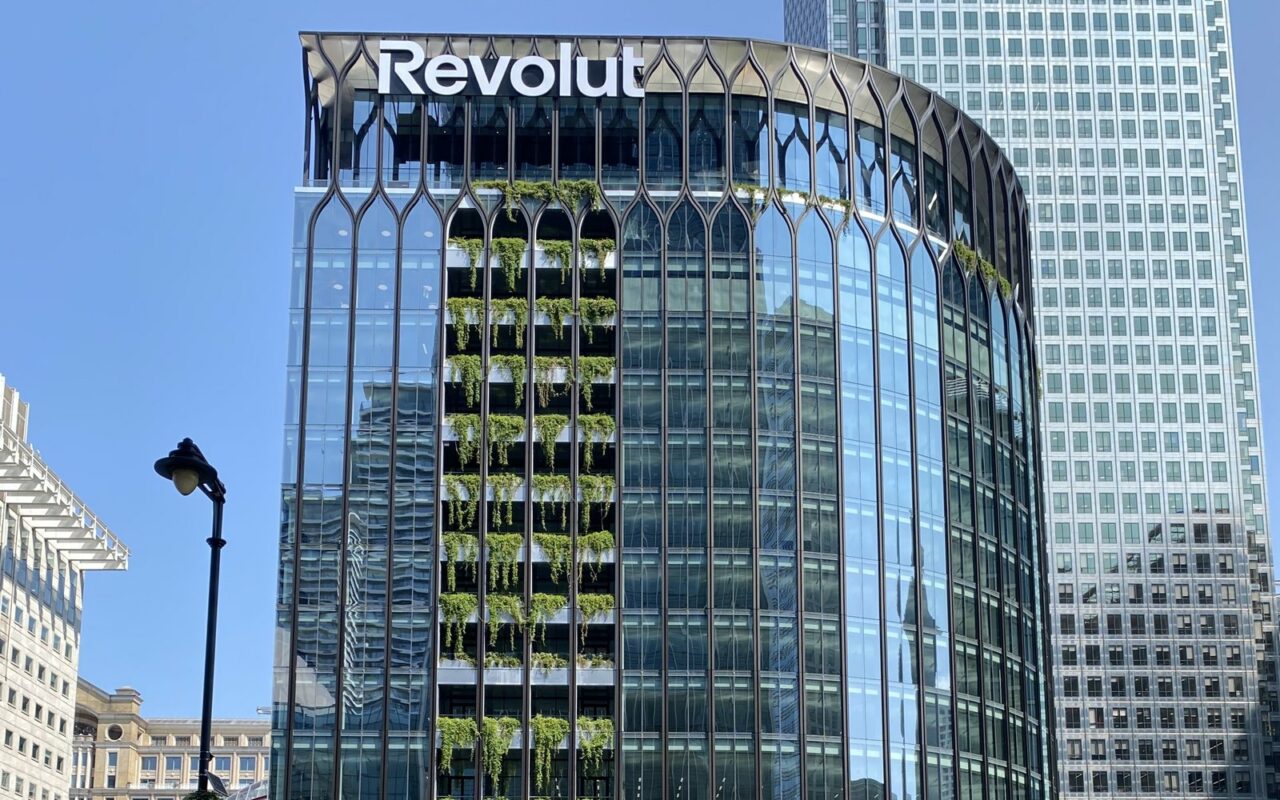 Immeuble vitré arrondi du siège de Revolut à Canary Wharf, Londres, avec le logo Revolut au sommet