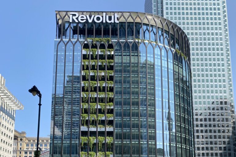 Immeuble vitré arrondi du siège de Revolut à Canary Wharf, Londres, avec le logo Revolut au sommet