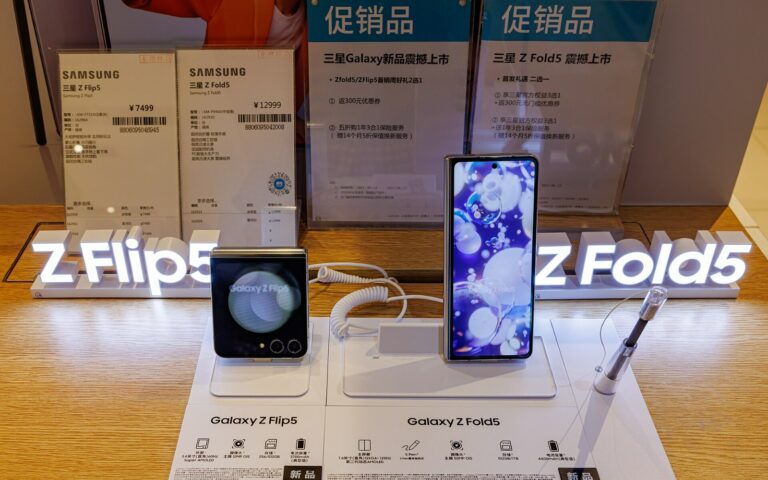 Deux smartphones pliants Samsung, un Galaxy Z Flip 5 et un Galaxy Z Fold 5, posés sur un présentoir de magasin.